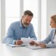 Mutuelle vs compagnie d’assurance traditionnelle pour l’auto : les différences Deux personnes comparant des contrats d'assurance auto sur une table
