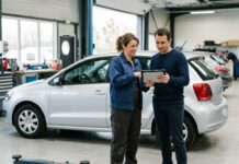 Garantie protection juridique auto : ce qu’elle couvre au-delà du recours pénal Client et professionnel discutant d'un litige automobile avec une tablette dans un garage