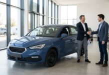 Assurance auto vendue par un constructeur automobile : ce que ça change vraiment Client et conseiller se serrant la main devant une voiture dans un showroom automobile