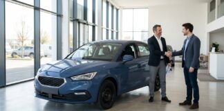 Assurance auto vendue par un constructeur automobile : ce que ça change vraiment Client et conseiller se serrant la main devant une voiture dans un showroom automobile