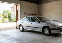 Assurance auto pour un véhicule ancien non collection (10 à 25 ans) : quelle formule choisir Berline ancienne bien entretenue garée dans un garage privé, illustrant le choix entre assurance tous risques et tiers étendu pour un véhicule non collection