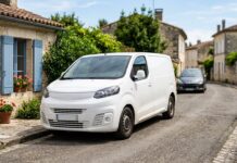 Assurance auto pour véhicule utilitaire à usage mixte : ce qui change vraiment Utilitaire blanc garé dans une rue résidentielle, illustrant un usage mixte professionnel et privé