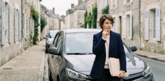 Bureau central de tarification : que faire quand aucun assureur ne veut de vous Conductrice devant sa voiture garée dans une rue française, un dossier de papiers sous le bras
