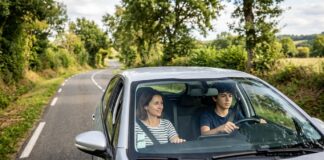 Conduite accompagnée : l’assurance à prévoir avant le premier trajet Un parent accompagne un adolescent au volant sur une route de campagne en conduite accompagnée