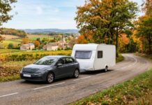 Assurer une remorque ou une caravane : ce que couvre votre assurance auto selon le poids Voiture tractant une caravane blanche sur une route de campagne française en automne